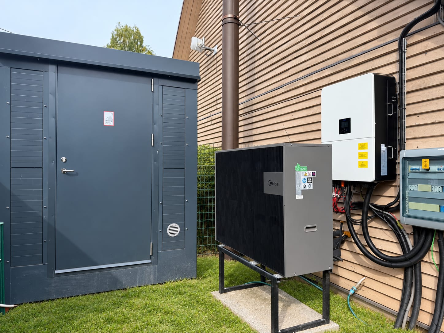 Paigaldatud energiasalvestuskonteiner eramu kõrval, seinal inverter ja elektrikilp